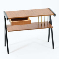 チーク材の天板とビーチ材の棚板、メタル支柱を組み合わせた異素材ミックスの構造が印象的で、ブラック塗装のフレームが全体を引き締めた軽快なデザインに仕上がっています。引き出し付きで小物収納に便利なほか、雑誌やレコードを立て掛けられる機能的な仕切りも備え、リビングや玄関先など多用途に活躍。北欧ビンテージらしい実用性と個性を兼ね備えた一台です。