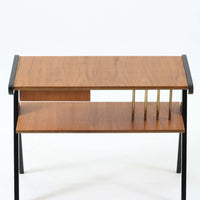 チーク材の天板とビーチ材の棚板、メタル支柱を組み合わせた異素材ミックスの構造が印象的で、ブラック塗装のフレームが全体を引き締めた軽快なデザインに仕上がっています。引き出し付きで小物収納に便利なほか、雑誌やレコードを立て掛けられる機能的な仕切りも備え、リビングや玄関先など多用途に活躍。北欧ビンテージらしい実用性と個性を兼ね備えた一台です。