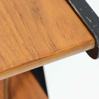 チーク材の天板とビーチ材の棚板、メタル支柱を組み合わせた異素材ミックスの構造が印象的で、ブラック塗装のフレームが全体を引き締めた軽快なデザインに仕上がっています。引き出し付きで小物収納に便利なほか、雑誌やレコードを立て掛けられる機能的な仕切りも備え、リビングや玄関先など多用途に活躍。北欧ビンテージらしい実用性と個性を兼ね備えた一台です。