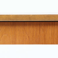 チーク材の天板とビーチ材の棚板、メタル支柱を組み合わせた異素材ミックスの構造が印象的で、ブラック塗装のフレームが全体を引き締めた軽快なデザインに仕上がっています。引き出し付きで小物収納に便利なほか、雑誌やレコードを立て掛けられる機能的な仕切りも備え、リビングや玄関先など多用途に活躍。北欧ビンテージらしい実用性と個性を兼ね備えた一台です。