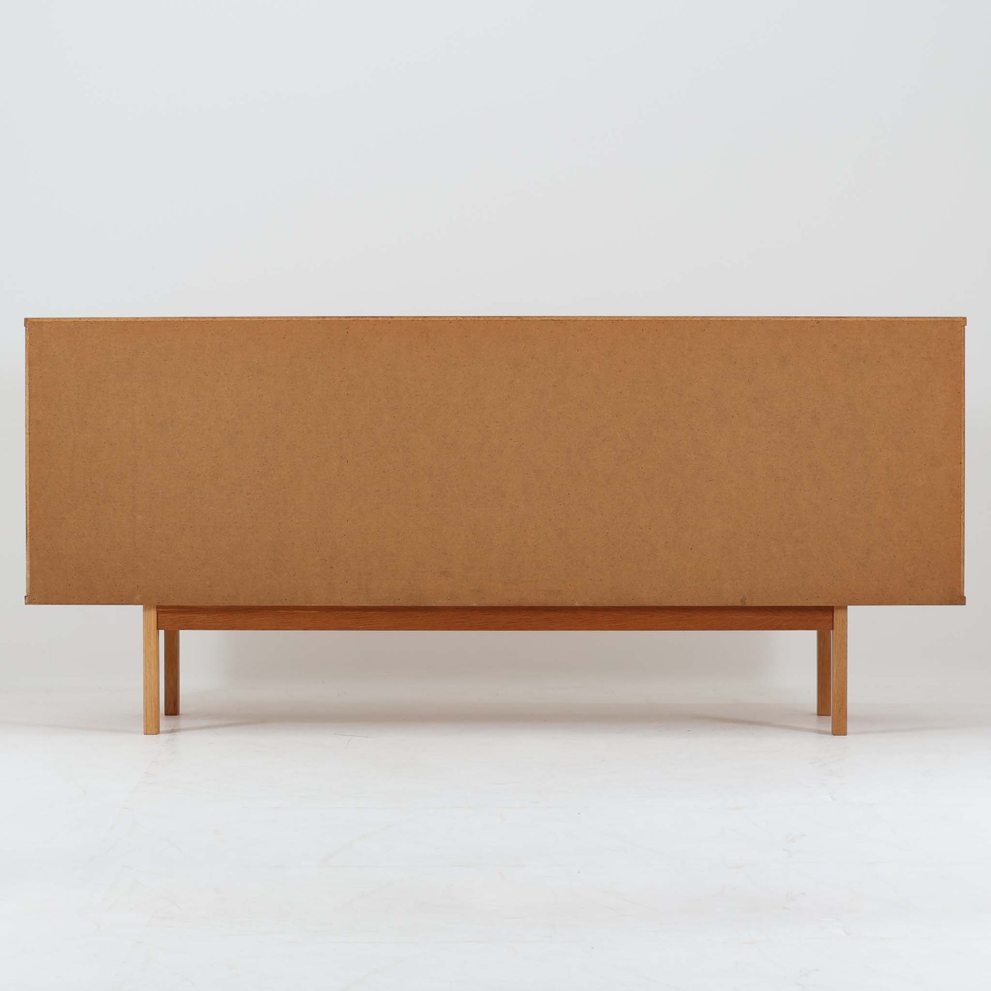 スウェーデン製収納キャビネットです。オーク材ならではの美しい木目と明るく上品な色合いが空間に軽やかな温もりを添え、幅180cmのワイドなサイズが高い収納力を実現します。中央の5段引き出しに加え、左右の扉内には棚板を備え、書類やカトラリー、リビング小物まで用途に応じて整理しやすい実用的な構成。細身の脚部が全体に抜け感を与え、北欧らしいミニマルで端正な佇まいが魅力です。リビングのサイドボードやダイニングでの収納家具としてはもちろん、ショップ什器としても映える、ビンテージならではの希少性と丁寧な木工技術を感じられる一台です。