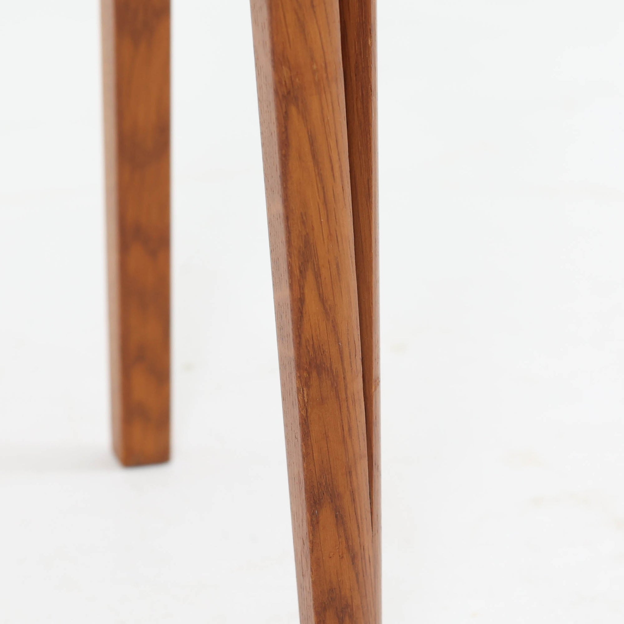 スウェーデンで製作されたコンソールテーブルです。天板にはチーク材、脚部にはオーク材を組み合わせ、温かみのある木目と落ち着いた色合いが北欧らしい上品な雰囲気を演出します。天板下には引き出しが備えられており、小物や文具などをすっきり収納できる実用的な構造。丸みを帯びた天板の角や細身のテーパー脚が軽やかな印象を与え、玄関やリビング、ベッドサイドなど限られたスペースにも収まりやすいサイズ感です。経年により深みを増した木部の表情が魅力の北欧ビンテージ家具です。