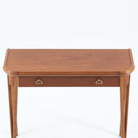 スウェーデンで製作されたコンソールテーブルです。天板にはチーク材、脚部にはオーク材を組み合わせ、温かみのある木目と落ち着いた色合いが北欧らしい上品な雰囲気を演出します。天板下には引き出しが備えられており、小物や文具などをすっきり収納できる実用的な構造。丸みを帯びた天板の角や細身のテーパー脚が軽やかな印象を与え、玄関やリビング、ベッドサイドなど限られたスペースにも収まりやすいサイズ感です。経年により深みを増した木部の表情が魅力の北欧ビンテージ家具です。