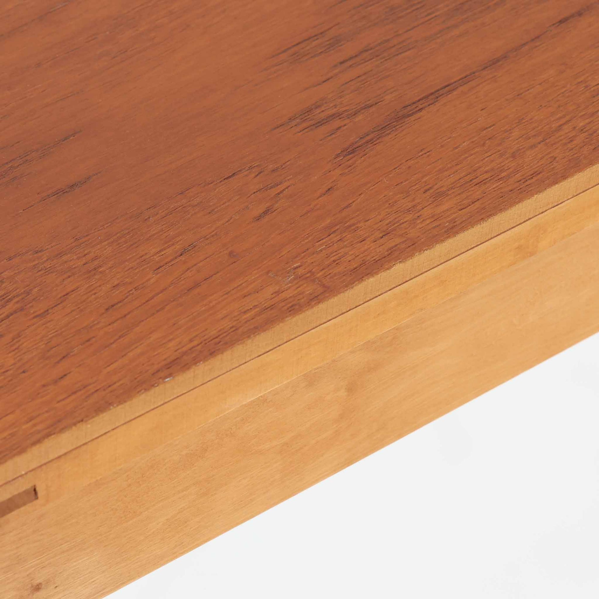 スウェーデンで製作されたコンソールテーブルです。天板にはチーク材、脚部にはオーク材を組み合わせ、温かみのある木目と落ち着いた色合いが北欧らしい上品な雰囲気を演出します。天板下には引き出しが備えられており、小物や文具などをすっきり収納できる実用的な構造。丸みを帯びた天板の角や細身のテーパー脚が軽やかな印象を与え、玄関やリビング、ベッドサイドなど限られたスペースにも収まりやすいサイズ感です。経年により深みを増した木部の表情が魅力の北欧ビンテージ家具です。