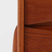 Rimbert Sandholdtがデザインし、Ateljé Glas & Träが手掛けたModel 6835の2段チェストです。チーク材の美しい木目と経年により深みを増した色艶に加え、引き出し前板に施された立体的な波状の削り出しデザインが印象的で、彫刻的な存在感を放ちます。シンプルな構造の中に高い造形美が感じられ、細身の脚部が軽やかな印象を添えます。コンパクトなサイズ感でベッドサイドやリビングでの小物収納に適し、空間のアクセントとしても映える希少性の高いビンテージアイテムです。