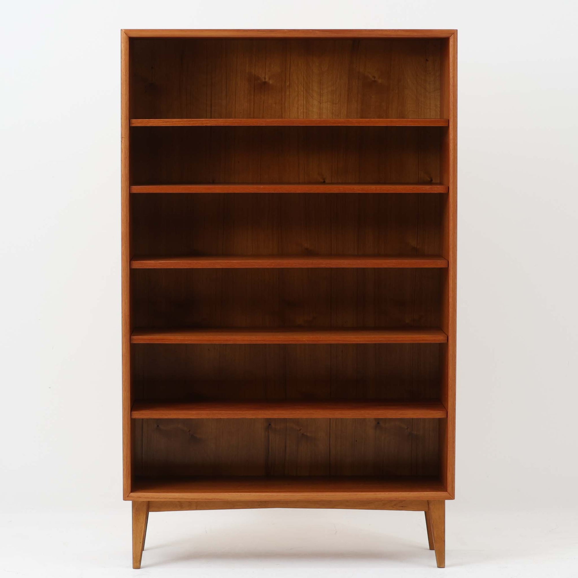 チーク材とビーチ材を組み合わせた温かみのある木肌が魅力のブックシェルフです。すっきりとした直線的なフォルムに対し、内側の深みある木目が美しく映え、空間に落ち着いた存在感をもたらします。北欧らしい実用性と端正な佇まいを備え、細身の脚部によって軽やかな印象に仕上げられています。書籍や雑貨の収納はもちろん、ディスプレイ棚としても活躍し、経年変化による色艶の深まりがビンテージならではの味わいを感じさせる一品です。