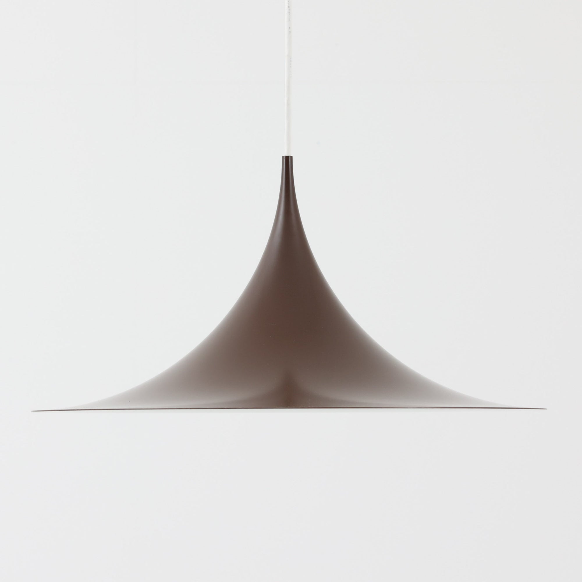 Claus BonderupとTorsten Thorupによるデザインのペンダントライト「Semi」は、Fog & Morup社から発表された北欧モダンを象徴する名作です。直径47cmのアルミシェードは美しい円錐を上下で切り取ったような独特のフォルムを持ち、光を下方向へ効率的に導きます。そのシャープでミニマルな造形は、空間にモダンな緊張感と優雅さをもたらし、ダイニングやリビングの中心を引き立てます。ビンテージならではの希少性と時を経た質感が一層の魅力を添え、北欧デザインの洗練を感じさせる一灯です。