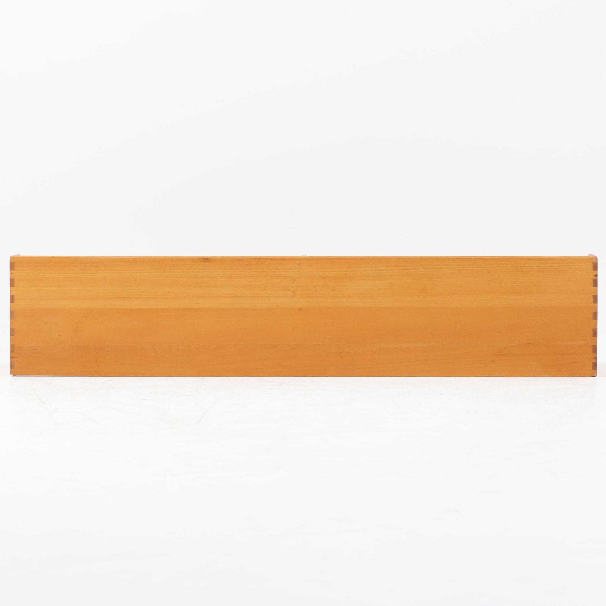 Borge Mogensen（ボーエ・モーエンセン）デザイン、FDB Mobler製のウォールシェルフ Model B5です。ビーチ無垢材を使用したシンプルで温かみのあるデザインが特徴で、北欧家具ならではの機能性と美しさを兼ね備えています。両サイドのパネルと背面のバー構造により、収納物が安定しやすく、実用性の高い設計となっています。中央の仕切りによって本や小物を整理しやすく、キッチンやリビング、書斎などさまざまな空間で活躍します。素朴で飽きのこないフォルムは、モーエンセンの「日常生活のための家具」という思想を体現したデザイン。デンマーク製の北欧ビンテージならではの味わい深い木の質感が魅力の一品です。