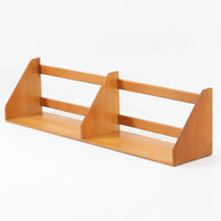 Borge Mogensen（ボーエ・モーエンセン）デザイン、FDB Mobler製のウォールシェルフ Model B5です。ビーチ無垢材を使用したシンプルで温かみのあるデザインが特徴で、北欧家具ならではの機能性と美しさを兼ね備えています。両サイドのパネルと背面のバー構造により、収納物が安定しやすく、実用性の高い設計となっています。中央の仕切りによって本や小物を整理しやすく、キッチンやリビング、書斎などさまざまな空間で活躍します。素朴で飽きのこないフォルムは、モーエンセンの「日常生活のための家具」という思想を体現したデザイン。デンマーク製の北欧ビンテージならではの味わい深い木の質感が魅力の一品です。