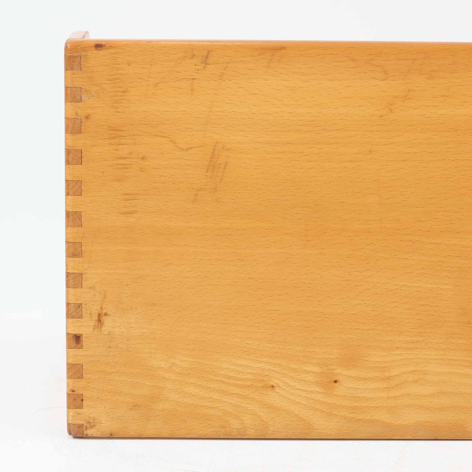 Borge Mogensen（ボーエ・モーエンセン）デザイン、FDB Mobler製のウォールシェルフ Model B5です。ビーチ無垢材を使用したシンプルで温かみのあるデザインが特徴で、北欧家具ならではの機能性と美しさを兼ね備えています。両サイドのパネルと背面のバー構造により、収納物が安定しやすく、実用性の高い設計となっています。中央の仕切りによって本や小物を整理しやすく、キッチンやリビング、書斎などさまざまな空間で活躍します。素朴で飽きのこないフォルムは、モーエンセンの「日常生活のための家具」という思想を体現したデザイン。デンマーク製の北欧ビンテージならではの味わい深い木の質感が魅力の一品です。