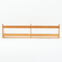 Borge Mogensen（ボーエ・モーエンセン）デザイン、FDB Mobler製のウォールシェルフ Model B5です。ビーチ無垢材を使用したシンプルで温かみのあるデザインが特徴で、北欧家具ならではの機能性と美しさを兼ね備えています。両サイドのパネルと背面のバー構造により、収納物が安定しやすく、実用性の高い設計となっています。中央の仕切りによって本や小物を整理しやすく、キッチンやリビング、書斎などさまざまな空間で活躍します。素朴で飽きのこないフォルムは、モーエンセンの「日常生活のための家具」という思想を体現したデザイン。デンマーク製の北欧ビンテージならではの味わい深い木の質感が魅力の一品です。