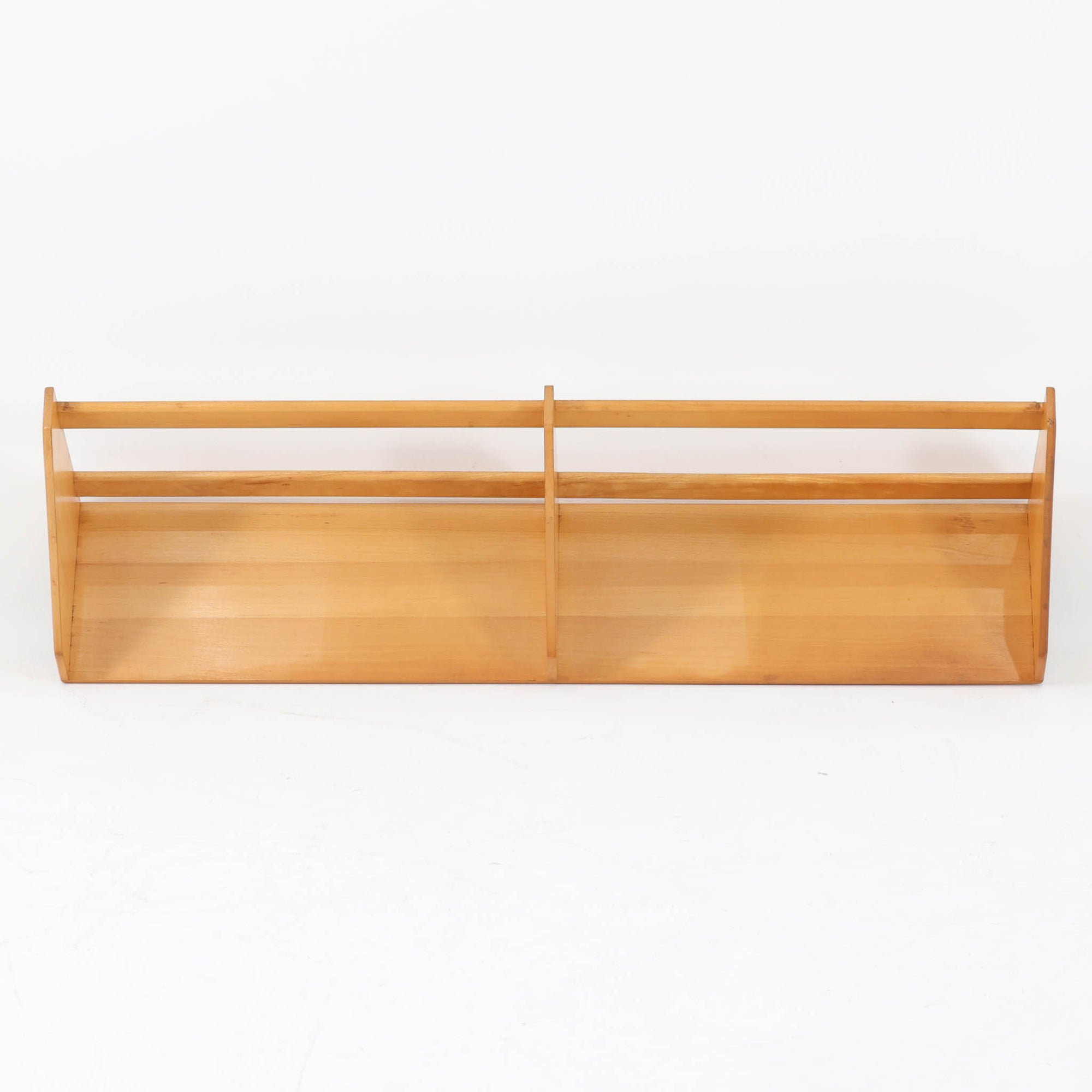 Borge Mogensen（ボーエ・モーエンセン）デザイン、FDB Mobler製のウォールシェルフ Model B5です。ビーチ無垢材を使用したシンプルで温かみのあるデザインが特徴で、北欧家具ならではの機能性と美しさを兼ね備えています。両サイドのパネルと背面のバー構造により、収納物が安定しやすく、実用性の高い設計となっています。中央の仕切りによって本や小物を整理しやすく、キッチンやリビング、書斎などさまざまな空間で活躍します。素朴で飽きのこないフォルムは、モーエンセンの「日常生活のための家具」という思想を体現したデザイン。デンマーク製の北欧ビンテージならではの味わい深い木の質感が魅力の一品です。