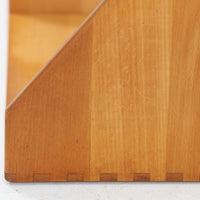 Borge Mogensen（ボーエ・モーエンセン）デザイン、FDB Mobler製のウォールシェルフ Model B5です。ビーチ無垢材を使用したシンプルで温かみのあるデザインが特徴で、北欧家具ならではの機能性と美しさを兼ね備えています。両サイドのパネルと背面のバー構造により、収納物が安定しやすく、実用性の高い設計となっています。中央の仕切りによって本や小物を整理しやすく、キッチンやリビング、書斎などさまざまな空間で活躍します。素朴で飽きのこないフォルムは、モーエンセンの「日常生活のための家具」という思想を体現したデザイン。デンマーク製の北欧ビンテージならではの味わい深い木の質感が魅力の一品です。