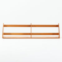 Borge Mogensen（ボーエ・モーエンセン）デザイン、FDB Mobler製のウォールシェルフ Model B5です。ビーチ無垢材を使用したシンプルで温かみのあるデザインが特徴で、北欧家具ならではの機能性と美しさを兼ね備えています。両サイドのパネルと背面のバー構造により、収納物が安定しやすく、実用性の高い設計となっています。中央の仕切りによって本や小物を整理しやすく、キッチンやリビング、書斎などさまざまな空間で活躍します。素朴で飽きのこないフォルムは、モーエンセンの「日常生活のための家具」という思想を体現したデザイン。デンマーク製の北欧ビンテージならではの味わい深い木の質感が魅力の一品です。