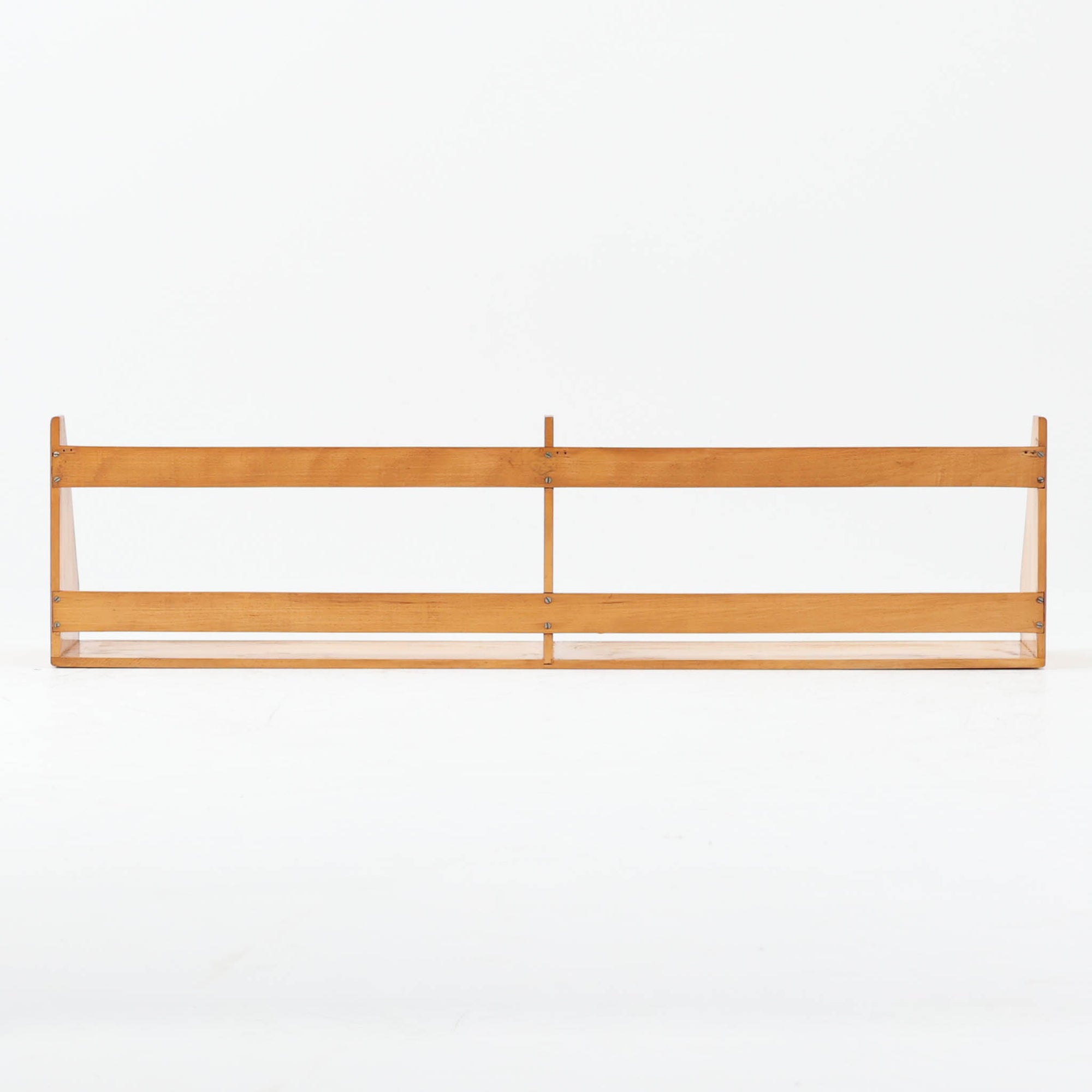 Borge Mogensen（ボーエ・モーエンセン）デザイン、FDB Mobler製のウォールシェルフ Model B5です。ビーチ無垢材を使用したシンプルで温かみのあるデザインが特徴で、北欧家具ならではの機能性と美しさを兼ね備えています。両サイドのパネルと背面のバー構造により、収納物が安定しやすく、実用性の高い設計となっています。中央の仕切りによって本や小物を整理しやすく、キッチンやリビング、書斎などさまざまな空間で活躍します。素朴で飽きのこないフォルムは、モーエンセンの「日常生活のための家具」という思想を体現したデザイン。デンマーク製の北欧ビンテージならではの味わい深い木の質感が魅力の一品です。