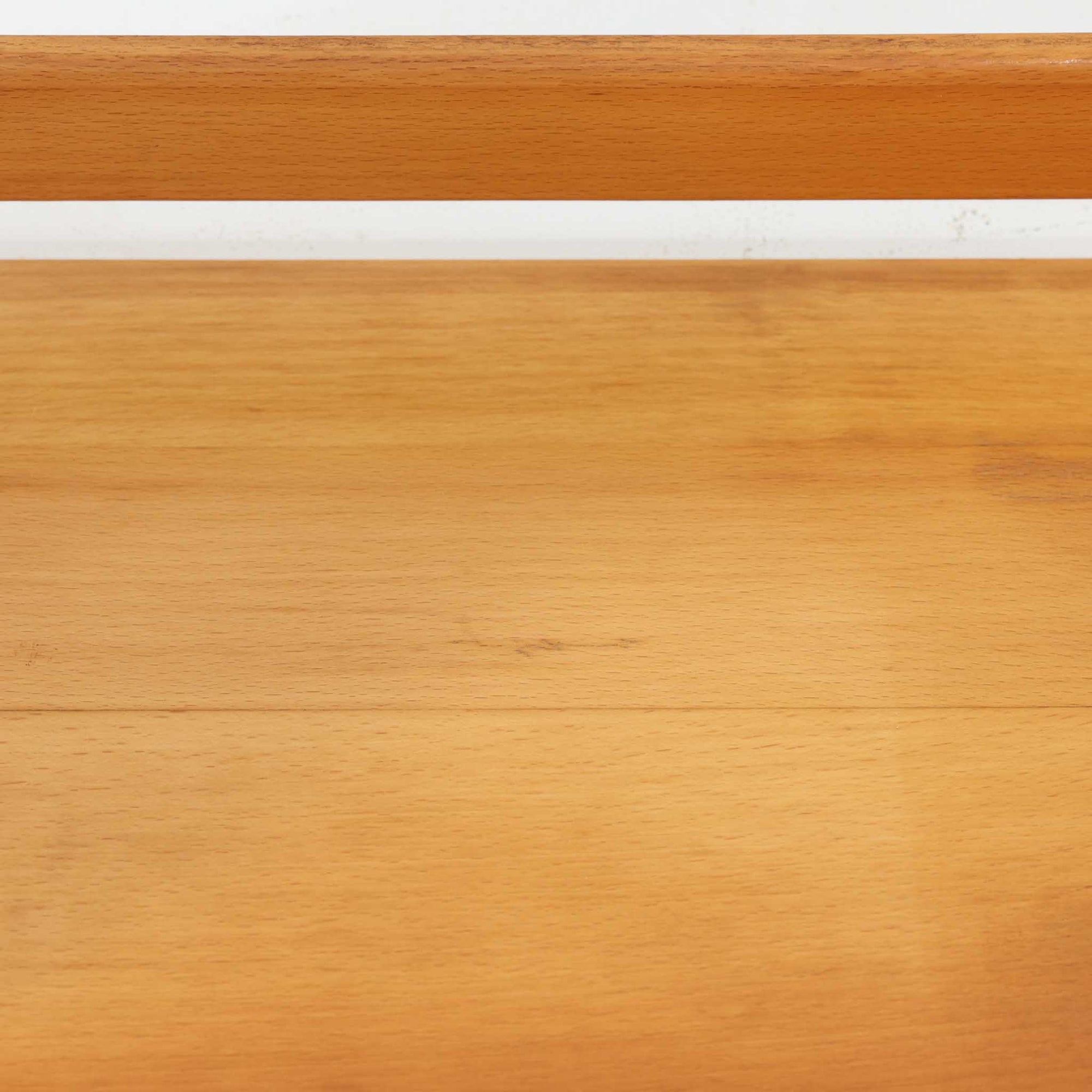 Borge Mogensen（ボーエ・モーエンセン）デザイン、FDB Mobler製のウォールシェルフ Model B5です。ビーチ無垢材を使用したシンプルで温かみのあるデザインが特徴で、北欧家具ならではの機能性と美しさを兼ね備えています。両サイドのパネルと背面のバー構造により、収納物が安定しやすく、実用性の高い設計となっています。中央の仕切りによって本や小物を整理しやすく、キッチンやリビング、書斎などさまざまな空間で活躍します。素朴で飽きのこないフォルムは、モーエンセンの「日常生活のための家具」という思想を体現したデザイン。デンマーク製の北欧ビンテージならではの味わい深い木の質感が魅力の一品です。