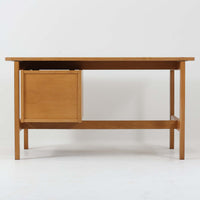 Hans J. Wegner（ハンス・J・ウェグナー）デザイン、Getama（ゲタマ）製GE156のオーク材片袖デスクです。幅125cmのゆとりある天板に、右側へ浮かぶように設けられた2段の片袖収納を組み合わせた、ウェグナーらしい端正な構造美が際立つ一台。無垢感のあるオークの木肌と軽快なフレーム構成が空間に明るく上質な印象をもたらし、書斎やホームオフィスはもちろん、ショップのワークテーブルとしても美しく映えます。引き出しは書類や文具を整理しやすく、下段には鍵付きで実用性も良好。名作椅子とも調和する洗練された佇まいと、北欧ビンテージならではの希少性が魅力のデスクです。