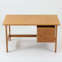 Hans J. Wegner（ハンス・J・ウェグナー）デザイン、Getama（ゲタマ）製GE156のオーク材片袖デスクです。幅125cmのゆとりある天板に、右側へ浮かぶように設けられた2段の片袖収納を組み合わせた、ウェグナーらしい端正な構造美が際立つ一台。無垢感のあるオークの木肌と軽快なフレーム構成が空間に明るく上質な印象をもたらし、書斎やホームオフィスはもちろん、ショップのワークテーブルとしても美しく映えます。引き出しは書類や文具を整理しやすく、下段には鍵付きで実用性も良好。名作椅子とも調和する洗練された佇まいと、北欧ビンテージならではの希少性が魅力のデスクです。