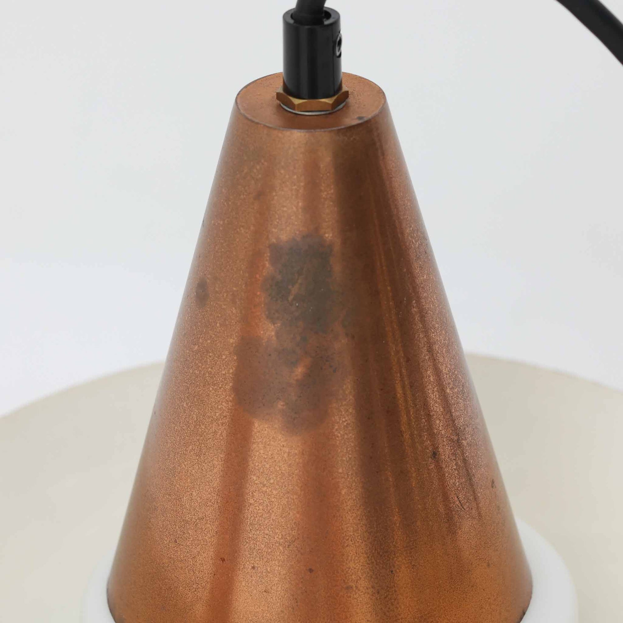 デンマーク製のビンテージペンダントライトです。スチール製のシェードを上下に重ね、下部にガラスを組み合わせた特徴的な構造で、シェードの隙間から漏れる光とガラスを透過する光が柔らかな表情を生み出します。ブラックを基調に上部の落ち着いたブラウン系カラーがアクセントとなり、直径21cmのコンパクトなサイズながら造形的な存在感があります。ダイニングやキッチン、玄関などのポイント照明にも取り入れやすく、素材の経年変化も含めてビンテージならではの趣を楽しめる一灯です。