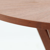Holger Georg Jensen（ホルガー・ジョージ・イェンセン）がデザインし、Tonder Mobelvaerkが製造を手掛けた「Kubus」シリーズのセンターテーブルです。チーク材を用いた円形天板には中心から放射状に広がる美しい木目が表れ、中央へ向かって伸びる彫刻的な脚部と十字型のベースが印象的。直径78cmの程よいサイズで、ソファまわりにも取り入れやすく、経年を重ねたチークの深みある風合いと造形美を存分に楽しめる北欧ビンテージです。