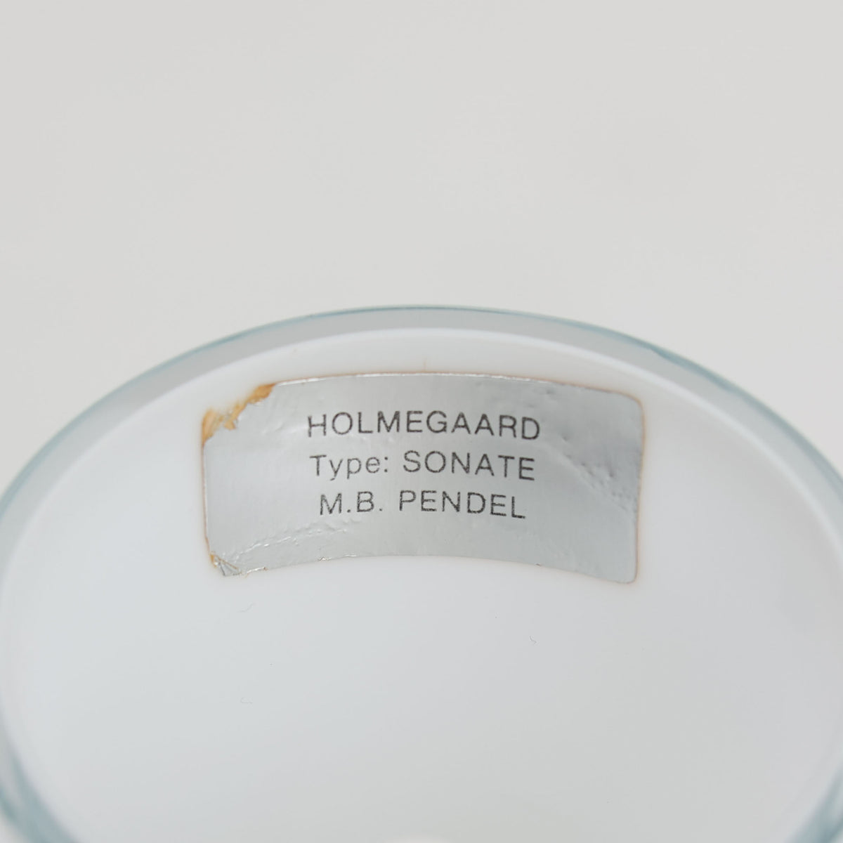 Holmegaardの「Sonate」は、Michael Bang（マイケル・バング）が手掛けたガラス製のペンダントライトです。乳白色のガラスによる柔らかな質感と、細いネックから緩やかに広がり、中央にボリュームを持たせた独特のフォルムが印象的。直径37cmの存在感あるサイズで、点灯時にはガラスを透過した穏やかな光が広がります。ダイニングやリビングの主照明として取り入れやすく、彫刻的な造形そのものも楽しめる北欧ビンテージらしい一灯です。