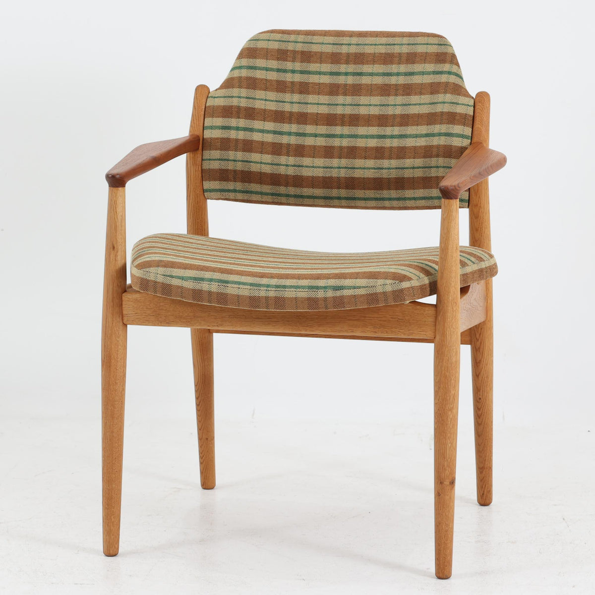 デンマークのデザイナー、Arne Vodder（アルネ・ヴォッダー）がデザインし、Sibast Mobelfabrik（シバスト・モブラー）が製造を手掛けたModel 62Aのアームチェア。オーク材を主体としたフレームにチーク材のアームレストを組み合わせ、異なる木材の色合いや質感が美しいアクセントを添えています。緩やかな曲線を描く背もたれとゆったりとした座面には、ブラウンやグリーンを基調とした温かみのあるチェック柄のファブリックを採用。すっきりとした脚部や丁寧に仕上げられた木部の造形には、北欧家具ならではの洗練された美しさが感じられます。ダイニングや書斎の椅子としてはもちろん、リビングの一角に置いても絵になる、ビンテージならではの味わい深い一脚です。
