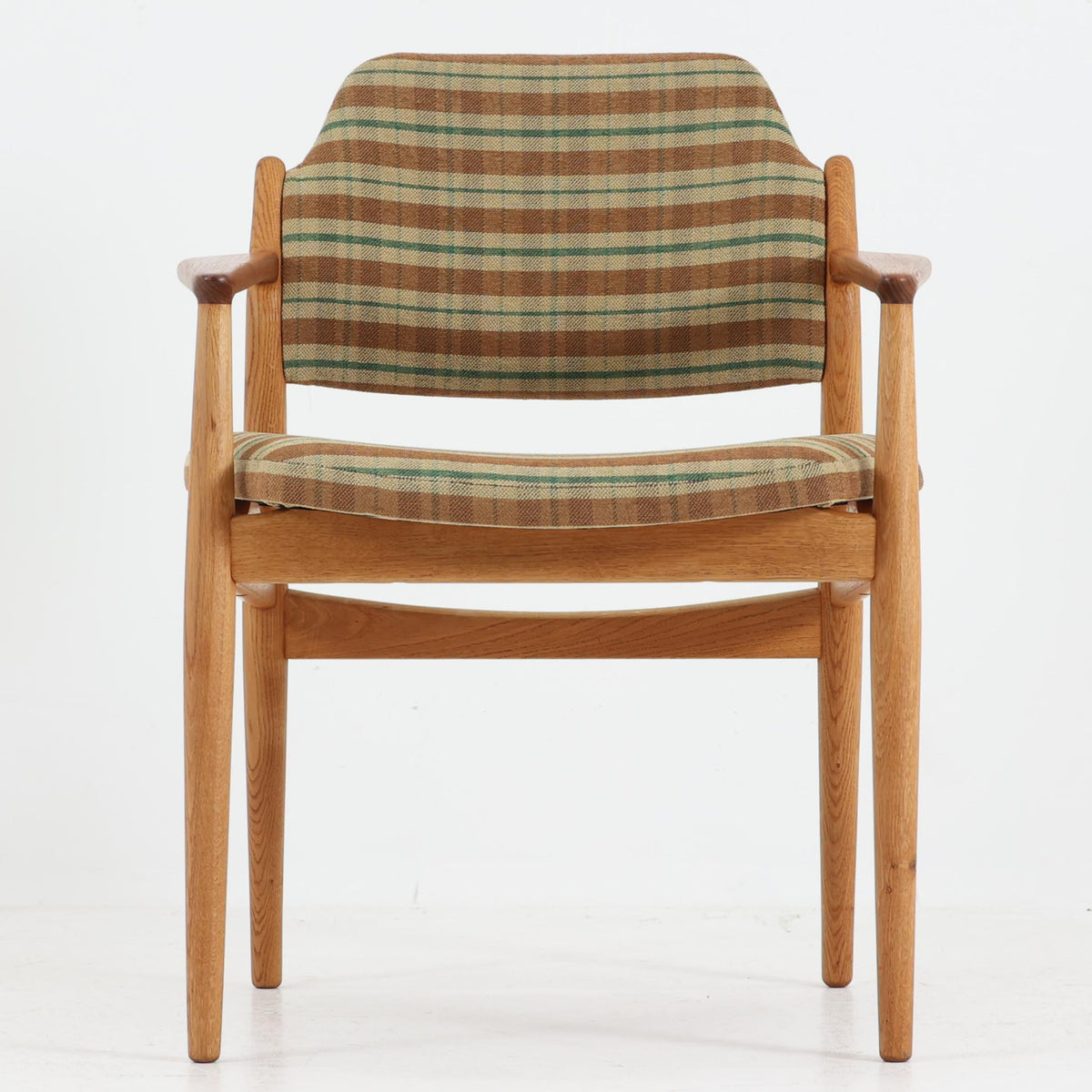 デンマークのデザイナー、Arne Vodder（アルネ・ヴォッダー）がデザインし、Sibast Mobelfabrik（シバスト・モブラー）が製造を手掛けたModel 62Aのアームチェア。オーク材を主体としたフレームにチーク材のアームレストを組み合わせ、異なる木材の色合いや質感が美しいアクセントを添えています。緩やかな曲線を描く背もたれとゆったりとした座面には、ブラウンやグリーンを基調とした温かみのあるチェック柄のファブリックを採用。すっきりとした脚部や丁寧に仕上げられた木部の造形には、北欧家具ならではの洗練された美しさが感じられます。ダイニングや書斎の椅子としてはもちろん、リビングの一角に置いても絵になる、ビンテージならではの味わい深い一脚です。
