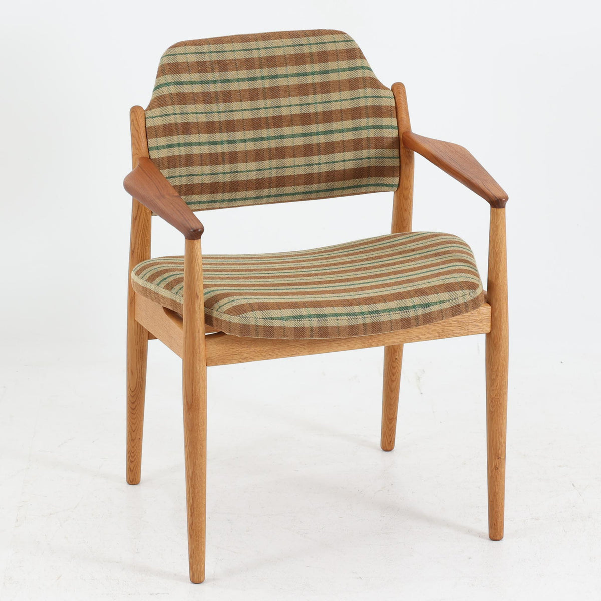 デンマークのデザイナー、Arne Vodder（アルネ・ヴォッダー）がデザインし、Sibast Mobelfabrik（シバスト・モブラー）が製造を手掛けたModel 62Aのアームチェア。オーク材を主体としたフレームにチーク材のアームレストを組み合わせ、異なる木材の色合いや質感が美しいアクセントを添えています。緩やかな曲線を描く背もたれとゆったりとした座面には、ブラウンやグリーンを基調とした温かみのあるチェック柄のファブリックを採用。すっきりとした脚部や丁寧に仕上げられた木部の造形には、北欧家具ならではの洗練された美しさが感じられます。ダイニングや書斎の椅子としてはもちろん、リビングの一角に置いても絵になる、ビンテージならではの味わい深い一脚です。