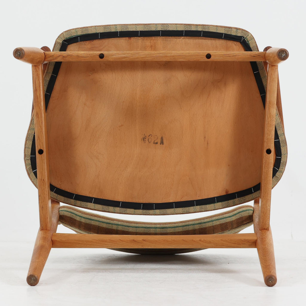 デンマークのデザイナー、Arne Vodder（アルネ・ヴォッダー）がデザインし、Sibast Mobelfabrik（シバスト・モブラー）が製造を手掛けたModel 62Aのアームチェア。オーク材を主体としたフレームにチーク材のアームレストを組み合わせ、異なる木材の色合いや質感が美しいアクセントを添えています。緩やかな曲線を描く背もたれとゆったりとした座面には、ブラウンやグリーンを基調とした温かみのあるチェック柄のファブリックを採用。すっきりとした脚部や丁寧に仕上げられた木部の造形には、北欧家具ならではの洗練された美しさが感じられます。ダイニングや書斎の椅子としてはもちろん、リビングの一角に置いても絵になる、ビンテージならではの味わい深い一脚です。
