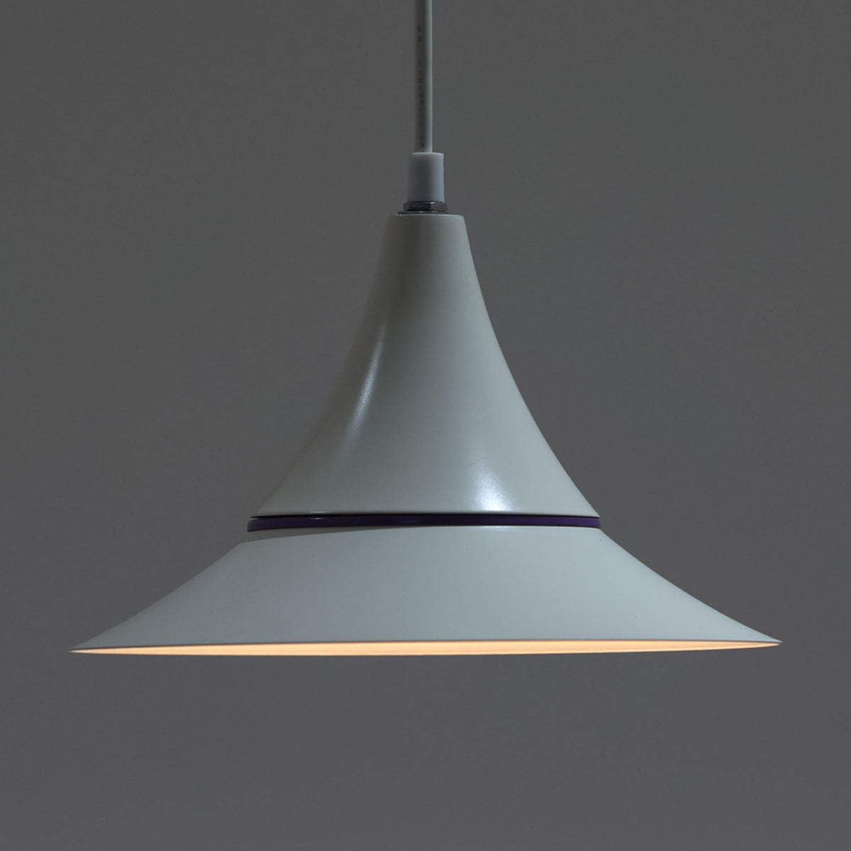 Design Lightの「Riva」は、デンマーク製のビンテージペンダントライトです。スチール製のシェードは、上部から裾へ滑らかに広がる優美なフォルムが特徴で、途中に配されたパープル系のラインがさりげないアクセントになっています。直径25cmのコンパクトなサイズながら造形的な存在感があり、ダイニングやキッチン、カウンターなどにも取り入れやすいデザイン。柔らかなアイボリー系の色合いと流麗なシルエットが、北欧ビンテージらしい趣を感じさせる一灯です。