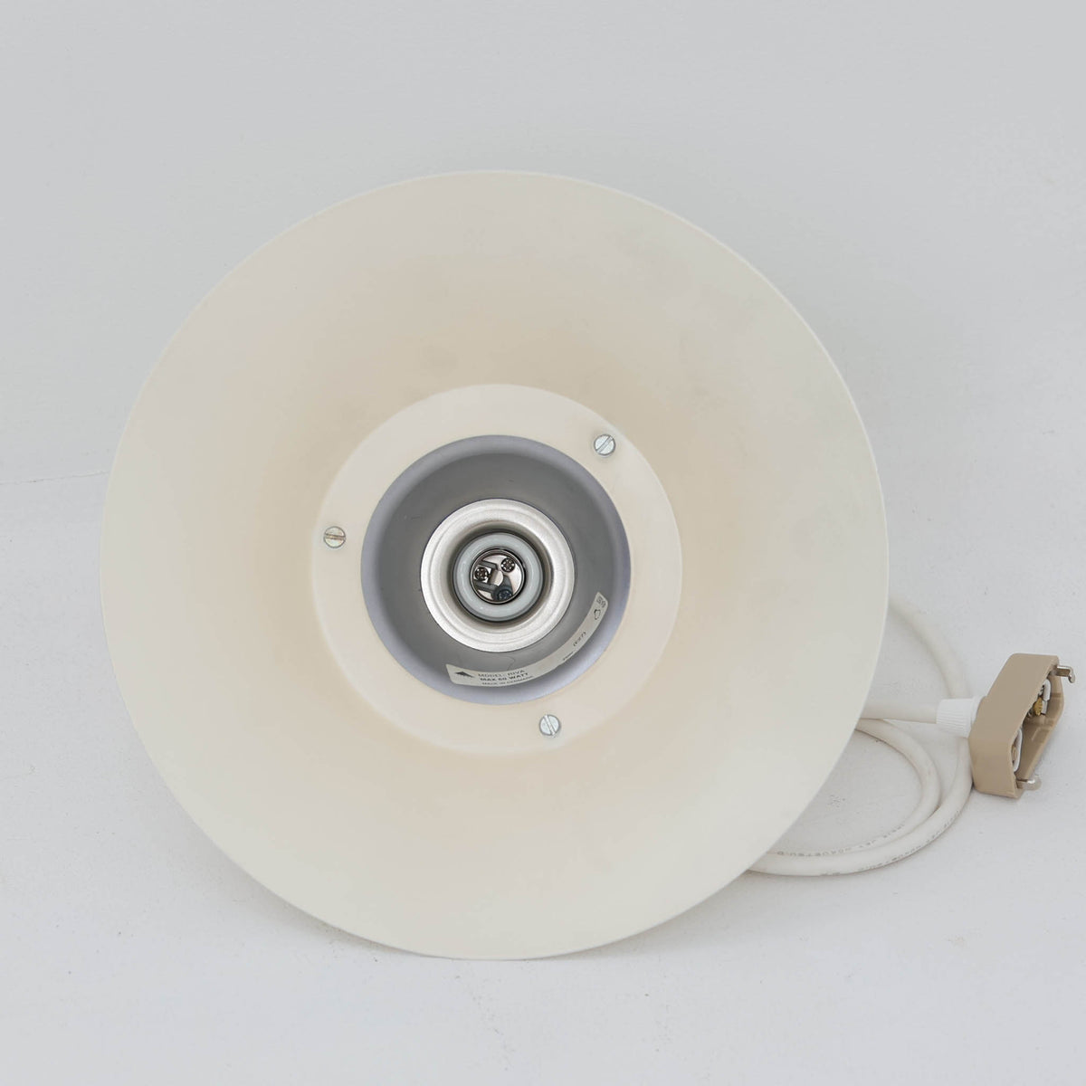 Design Lightの「Riva」は、デンマーク製のビンテージペンダントライトです。スチール製のシェードは、上部から裾へ滑らかに広がる優美なフォルムが特徴で、途中に配されたパープル系のラインがさりげないアクセントになっています。直径25cmのコンパクトなサイズながら造形的な存在感があり、ダイニングやキッチン、カウンターなどにも取り入れやすいデザイン。柔らかなアイボリー系の色合いと流麗なシルエットが、北欧ビンテージらしい趣を感じさせる一灯です。