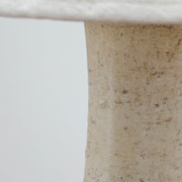 デンマークの陶磁器メーカーAxella Keramik（アクセラ）による、Jette Helleroe（イェッテ・ヘレロー）デザインのビンテージテーブルランプ。丸みを帯びたふっくらとしたベースから、細く伸びる首元へとつながる彫刻的なフォルムが印象的な一品です。温かみのあるアイボリーを基調に、深いブラウンの釉薬を大胆に配した独特の模様が特徴で、釉薬の自然な濃淡や境界のにじみが、手仕事ならではの豊かな表情を生み出しています。素朴さと芸術性を兼ね備えた佇まいは、北欧ビンテージならではの魅力を感じさせます。プリーツを施したリネンシェードは柔らかな光を広げ、落ち着いた温もりのある空間を演出します。リビングのサイドボードや寝室のチェストなどに置けば、消灯時にもオブジェのような存在感を楽しめます。