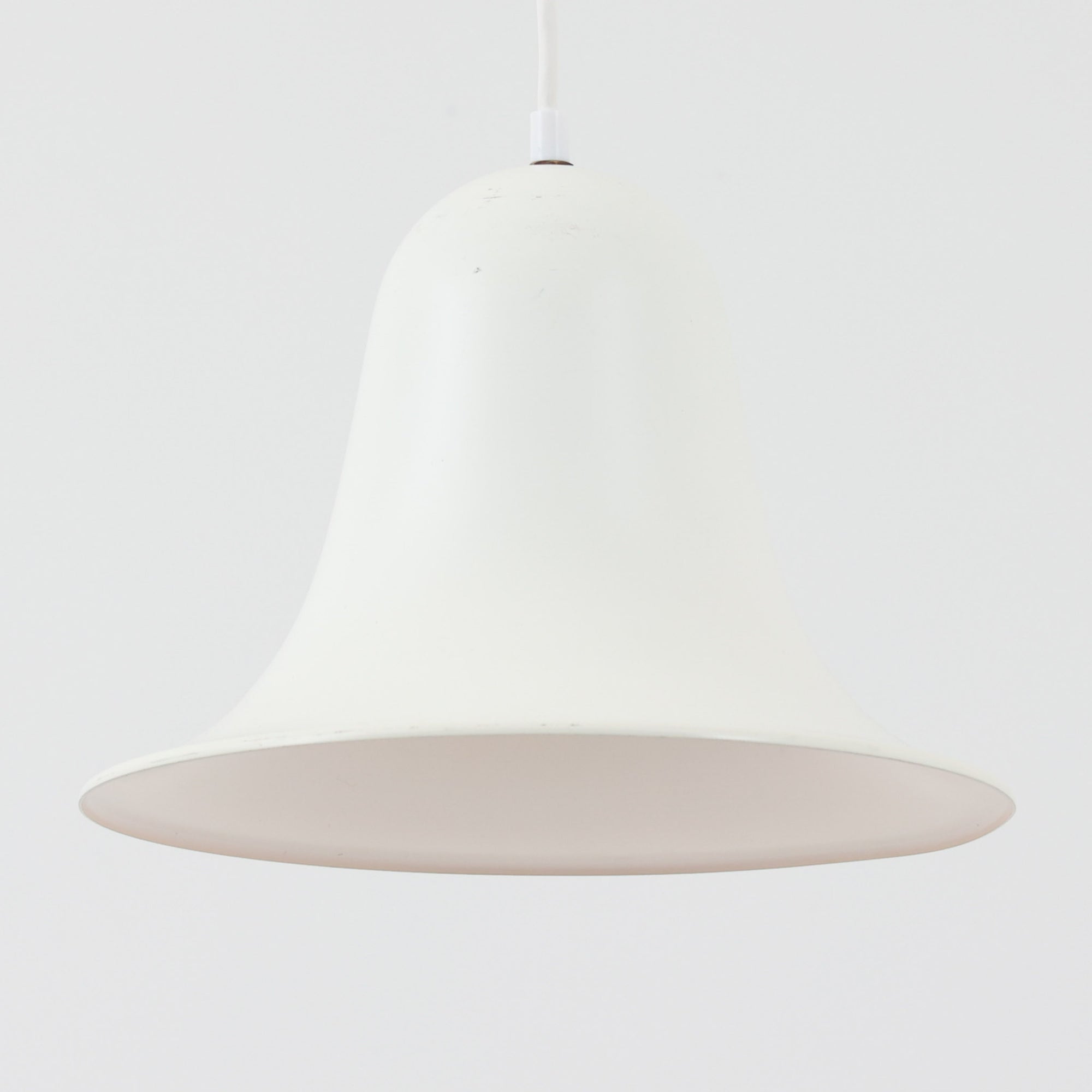 Verner Panton（ヴェルナー・パントン）による「Pantop」のペンダントライトです。アルミ製のシェードは、ベルを思わせる滑らかな曲線と大きく広がる裾が特徴で、シンプルながら彫刻的な存在感を備えています。光源をシェード内に収める構造により、点灯時には下方へ柔らかな光が広がり、ダイニングテーブルやカウンター上の照明としてもおすすめ。直径30cmの取り入れやすいサイズで、時代を経ても色褪せない造形美を楽しめる北欧ビンテージならではの一灯です。