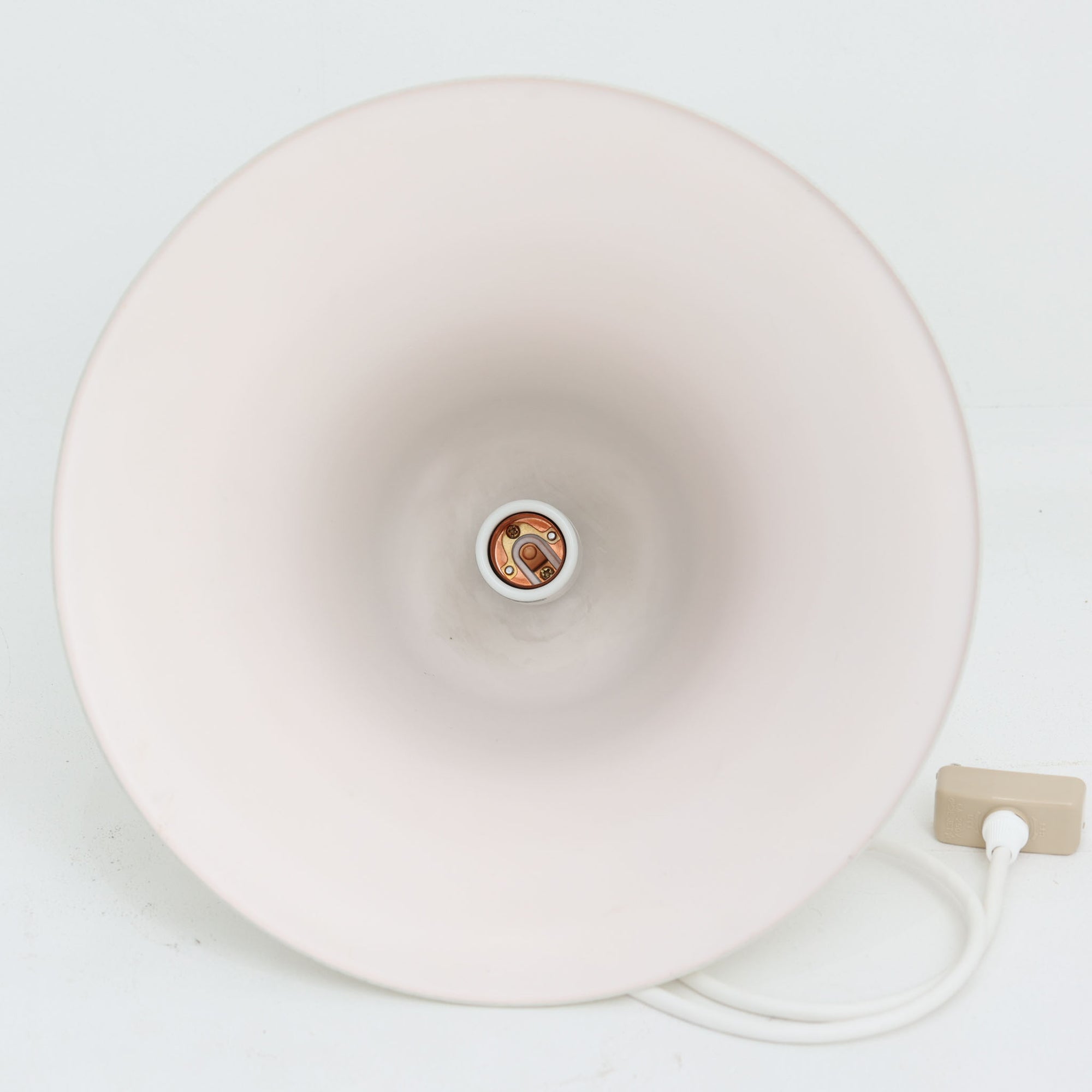 Verner Panton（ヴェルナー・パントン）による「Pantop」のペンダントライトです。アルミ製のシェードは、ベルを思わせる滑らかな曲線と大きく広がる裾が特徴で、シンプルながら彫刻的な存在感を備えています。光源をシェード内に収める構造により、点灯時には下方へ柔らかな光が広がり、ダイニングテーブルやカウンター上の照明としてもおすすめ。直径30cmの取り入れやすいサイズで、時代を経ても色褪せない造形美を楽しめる北欧ビンテージならではの一灯です。