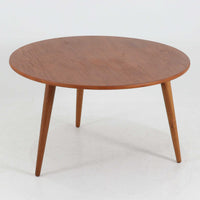 Hans J. Wegnerがデザインし、Andreas Tuckが製造を手掛けたAT8。チーク材の円形天板とオーク材の脚部を組み合わせ、異なる木材の表情を巧みに生かした一台です。直径98cmの伸びやかな天板を、外側へ緩やかに開く4本のテーパードレッグが軽快に支えるシンプルな構成で、素材とプロポーションの美しさが際立ちます。ソファを囲むリビングの主役として取り入れやすく、ウェグナーらしい端正な造形と年月を重ねた木部の風合いを味わえるビンテージ品です。