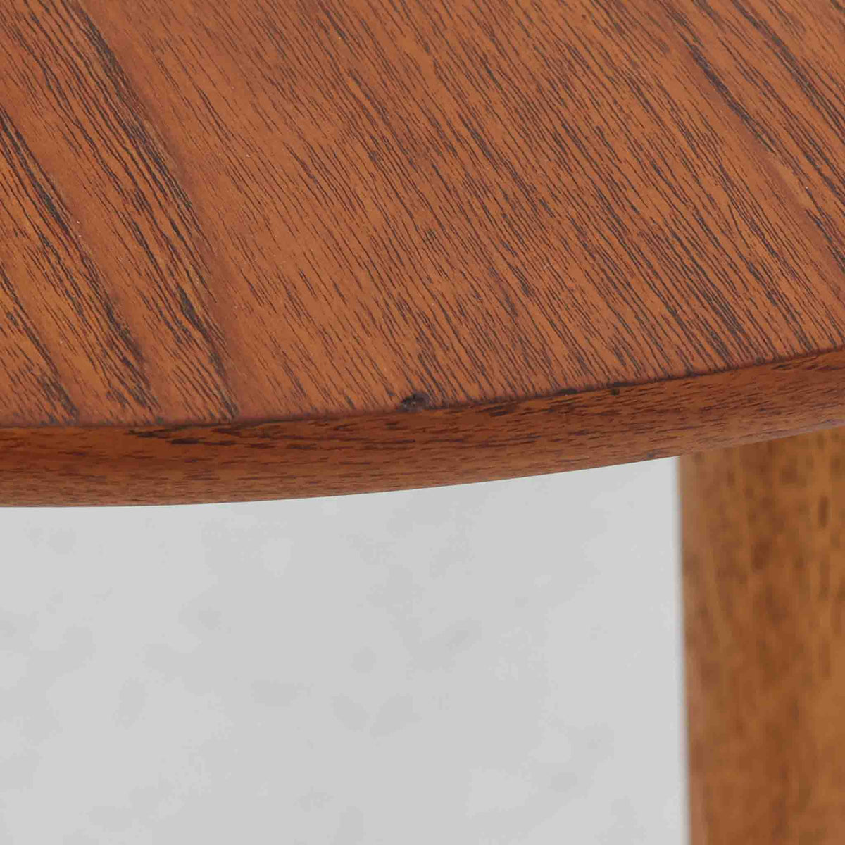 Hans J. Wegnerがデザインし、Andreas Tuckが製造を手掛けたAT8。チーク材の円形天板とオーク材の脚部を組み合わせ、異なる木材の表情を巧みに生かした一台です。直径98cmの伸びやかな天板を、外側へ緩やかに開く4本のテーパードレッグが軽快に支えるシンプルな構成で、素材とプロポーションの美しさが際立ちます。ソファを囲むリビングの主役として取り入れやすく、ウェグナーらしい端正な造形と年月を重ねた木部の風合いを味わえるビンテージ品です。
