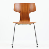 アルネ・ヤコブセンがデザインし、Fritz Hansenが製造した「T Chair」です。チーク材の成形合板による背座一体型のシェルは、背面上部を左右に広げた特徴的なシルエットと、身体に沿う緩やかな曲面が魅力。細身の金属脚との組み合わせが軽快で、ダイニングはもちろん、書斎や玄関のアクセントチェアにもおすすめです。美しい木目と時を重ねた風合い、合理的な構造に宿る北欧ビンテージらしい存在感を楽しめます。