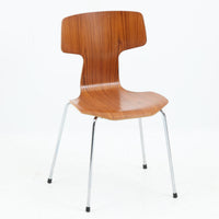 アルネ・ヤコブセンがデザインし、Fritz Hansenが製造した「T Chair」です。チーク材の成形合板による背座一体型のシェルは、背面上部を左右に広げた特徴的なシルエットと、身体に沿う緩やかな曲面が魅力。細身の金属脚との組み合わせが軽快で、ダイニングはもちろん、書斎や玄関のアクセントチェアにもおすすめです。美しい木目と時を重ねた風合い、合理的な構造に宿る北欧ビンテージらしい存在感を楽しめます。