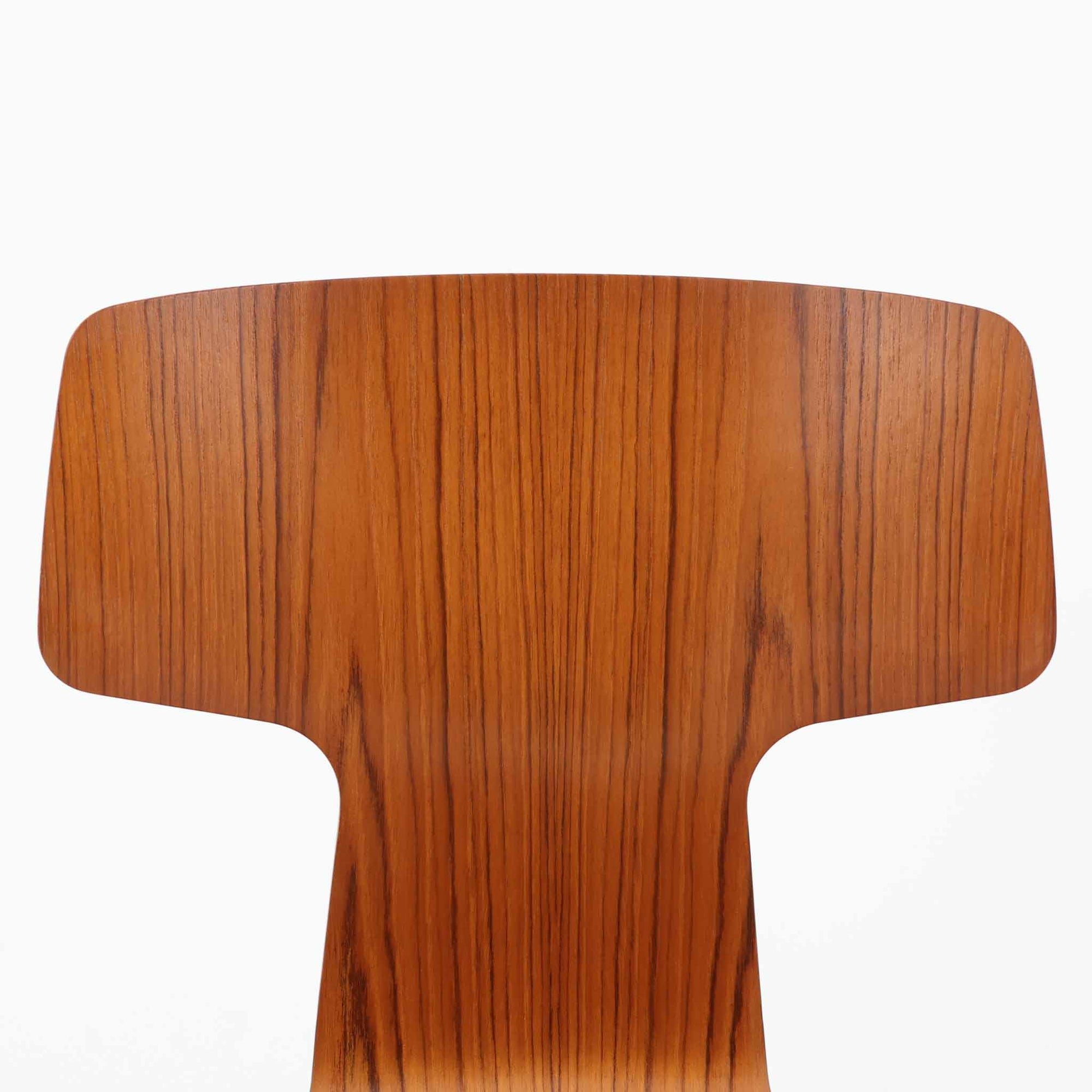 アルネ・ヤコブセンがデザインし、Fritz Hansenが製造した「T Chair」です。チーク材の成形合板による背座一体型のシェルは、背面上部を左右に広げた特徴的なシルエットと、身体に沿う緩やかな曲面が魅力。細身の金属脚との組み合わせが軽快で、ダイニングはもちろん、書斎や玄関のアクセントチェアにもおすすめです。美しい木目と時を重ねた風合い、合理的な構造に宿る北欧ビンテージらしい存在感を楽しめます。