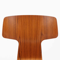 アルネ・ヤコブセンがデザインし、Fritz Hansenが製造した「T Chair」です。チーク材の成形合板による背座一体型のシェルは、背面上部を左右に広げた特徴的なシルエットと、身体に沿う緩やかな曲面が魅力。細身の金属脚との組み合わせが軽快で、ダイニングはもちろん、書斎や玄関のアクセントチェアにもおすすめです。美しい木目と時を重ねた風合い、合理的な構造に宿る北欧ビンテージらしい存在感を楽しめます。