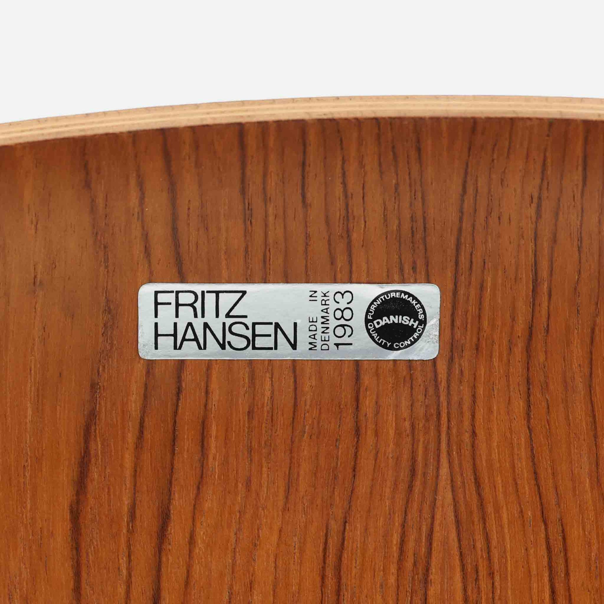 アルネ・ヤコブセンがデザインし、Fritz Hansenが製造した「T Chair」です。チーク材の成形合板による背座一体型のシェルは、背面上部を左右に広げた特徴的なシルエットと、身体に沿う緩やかな曲面が魅力。細身の金属脚との組み合わせが軽快で、ダイニングはもちろん、書斎や玄関のアクセントチェアにもおすすめです。美しい木目と時を重ねた風合い、合理的な構造に宿る北欧ビンテージらしい存在感を楽しめます。
