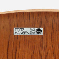 アルネ・ヤコブセンがデザインし、Fritz Hansenが製造した「T Chair」です。チーク材の成形合板による背座一体型のシェルは、背面上部を左右に広げた特徴的なシルエットと、身体に沿う緩やかな曲面が魅力。細身の金属脚との組み合わせが軽快で、ダイニングはもちろん、書斎や玄関のアクセントチェアにもおすすめです。美しい木目と時を重ねた風合い、合理的な構造に宿る北欧ビンテージらしい存在感を楽しめます。