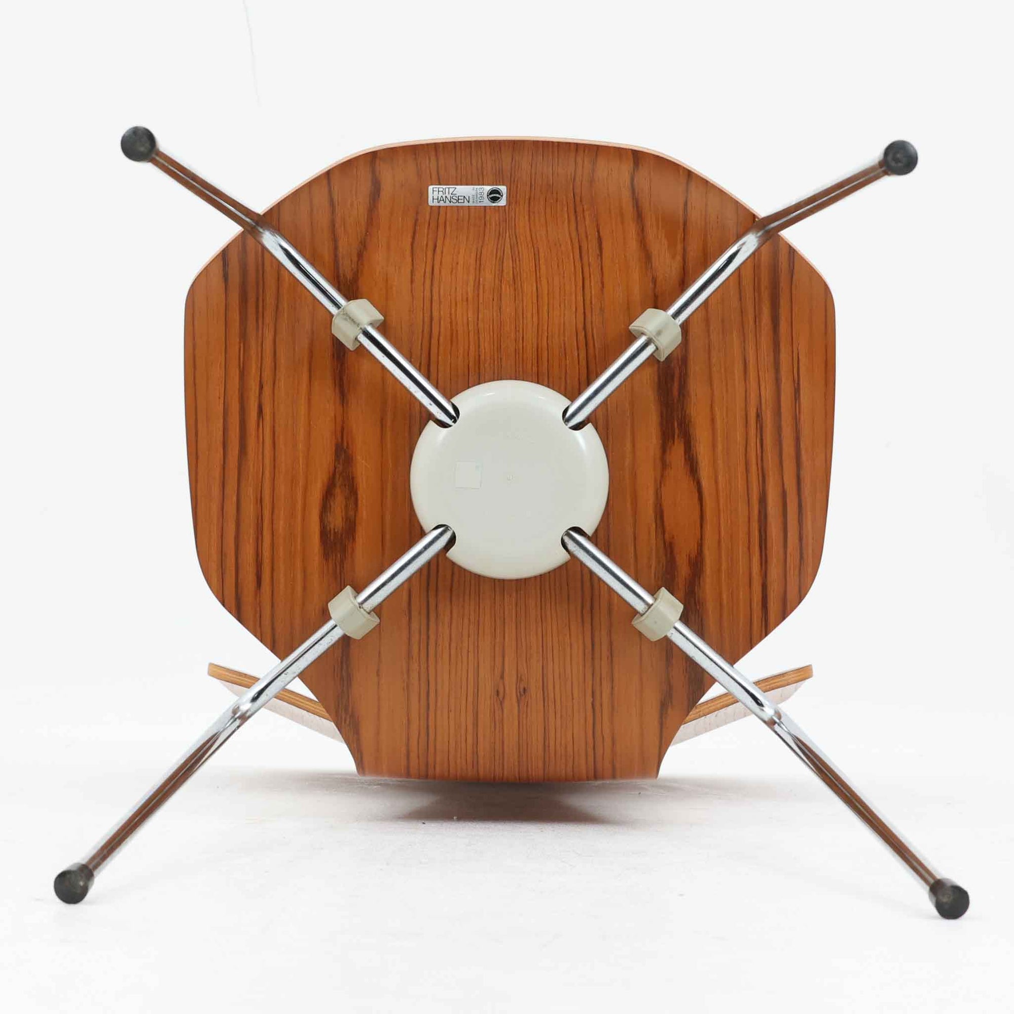 アルネ・ヤコブセンがデザインし、Fritz Hansenが製造した「T Chair」です。チーク材の成形合板による背座一体型のシェルは、背面上部を左右に広げた特徴的なシルエットと、身体に沿う緩やかな曲面が魅力。細身の金属脚との組み合わせが軽快で、ダイニングはもちろん、書斎や玄関のアクセントチェアにもおすすめです。美しい木目と時を重ねた風合い、合理的な構造に宿る北欧ビンテージらしい存在感を楽しめます。