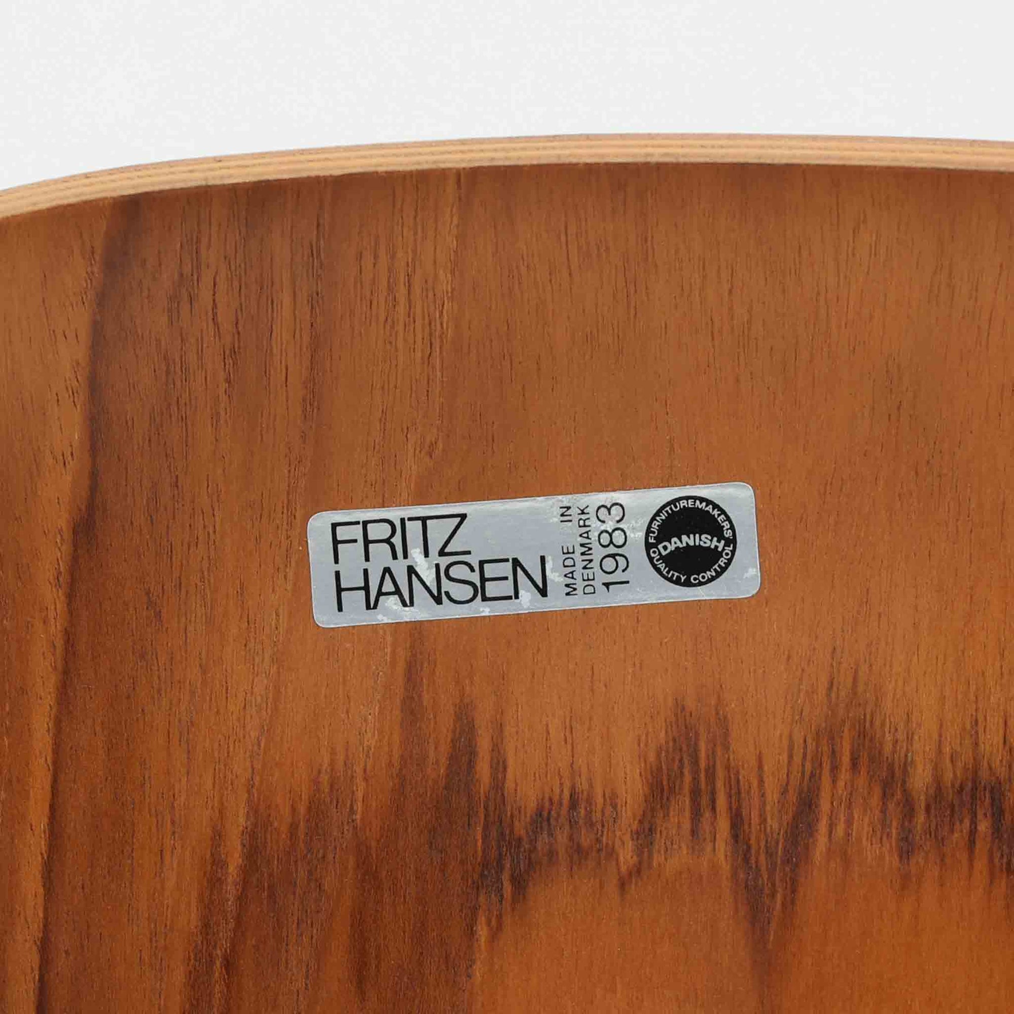 アルネ・ヤコブセンがデザインし、Fritz Hansenが製造した「T Chair」です。チーク材の成形合板による背座一体型のシェルは、背面上部を左右に広げた特徴的なシルエットと、身体に沿う緩やかな曲面が魅力。細身の金属脚との組み合わせが軽快で、ダイニングはもちろん、書斎や玄関のアクセントチェアにもおすすめです。美しい木目と時を重ねた風合い、合理的な構造に宿る北欧ビンテージらしい存在感を楽しめます。