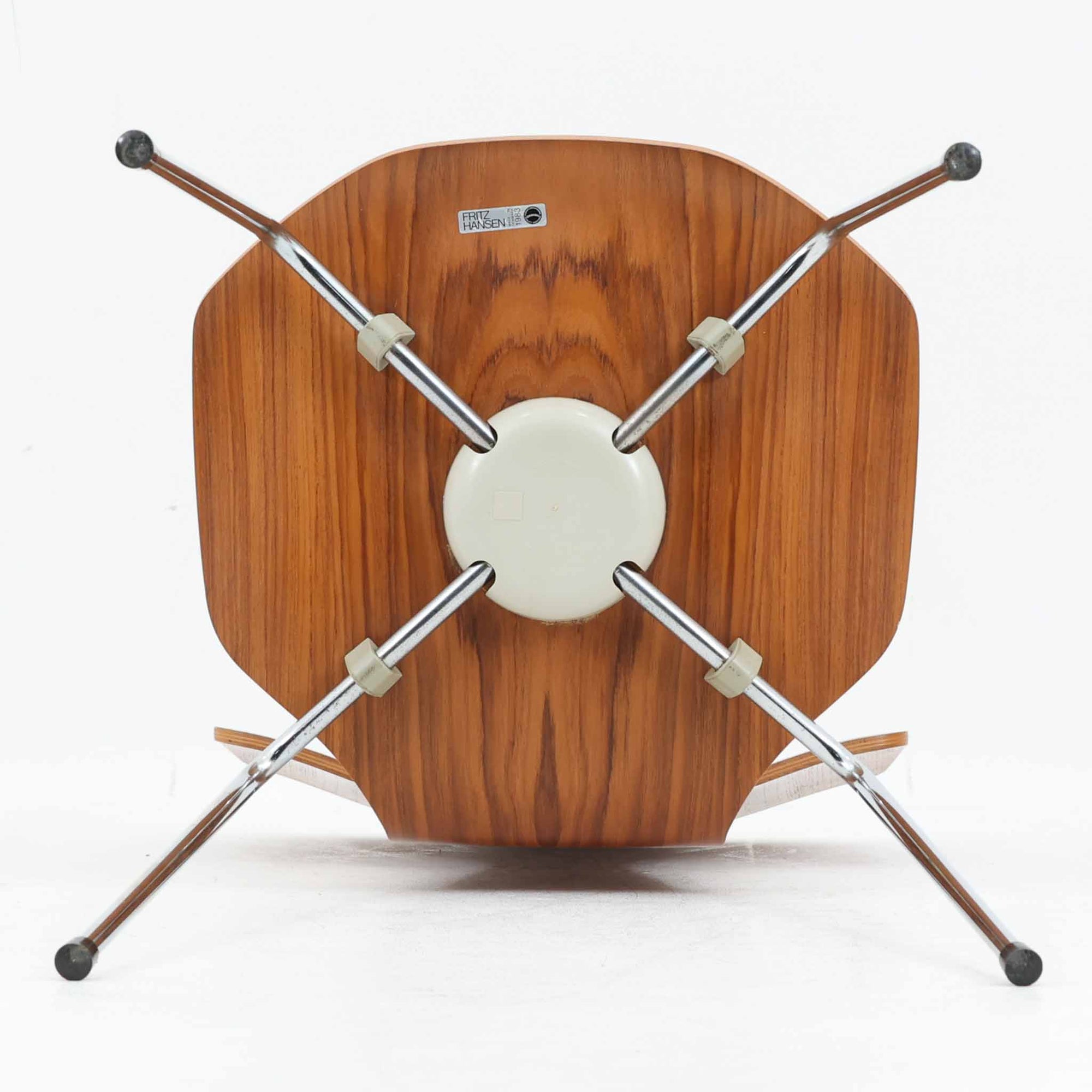 アルネ・ヤコブセンがデザインし、Fritz Hansenが製造した「T Chair」です。チーク材の成形合板による背座一体型のシェルは、背面上部を左右に広げた特徴的なシルエットと、身体に沿う緩やかな曲面が魅力。細身の金属脚との組み合わせが軽快で、ダイニングはもちろん、書斎や玄関のアクセントチェアにもおすすめです。美しい木目と時を重ねた風合い、合理的な構造に宿る北欧ビンテージらしい存在感を楽しめます。