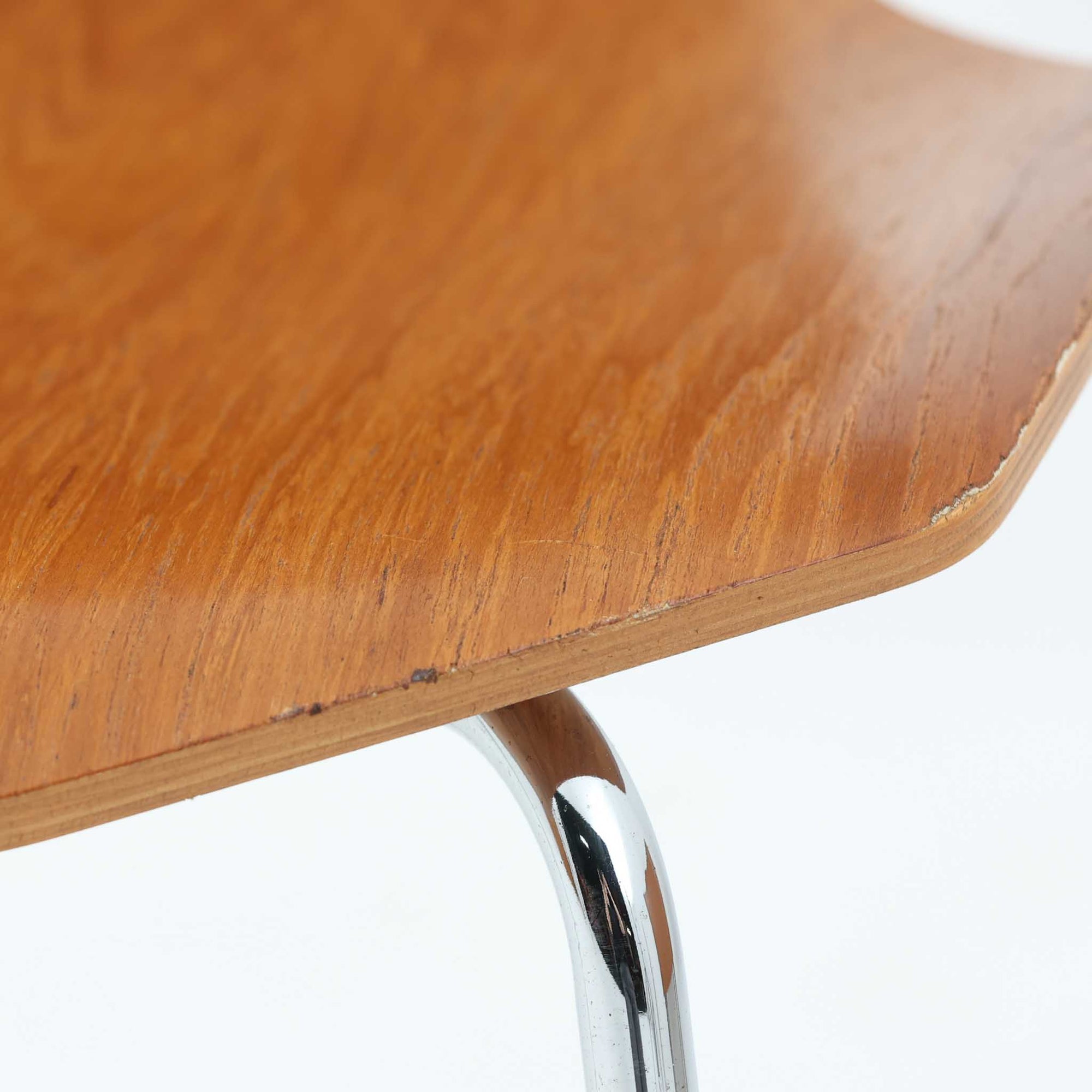 アルネ・ヤコブセンがデザインし、Fritz Hansenが製造した「T Chair」です。チーク材の成形合板による背座一体型のシェルは、背面上部を左右に広げた特徴的なシルエットと、身体に沿う緩やかな曲面が魅力。細身の金属脚との組み合わせが軽快で、ダイニングはもちろん、書斎や玄関のアクセントチェアにもおすすめです。美しい木目と時を重ねた風合い、合理的な構造に宿る北欧ビンテージらしい存在感を楽しめます。