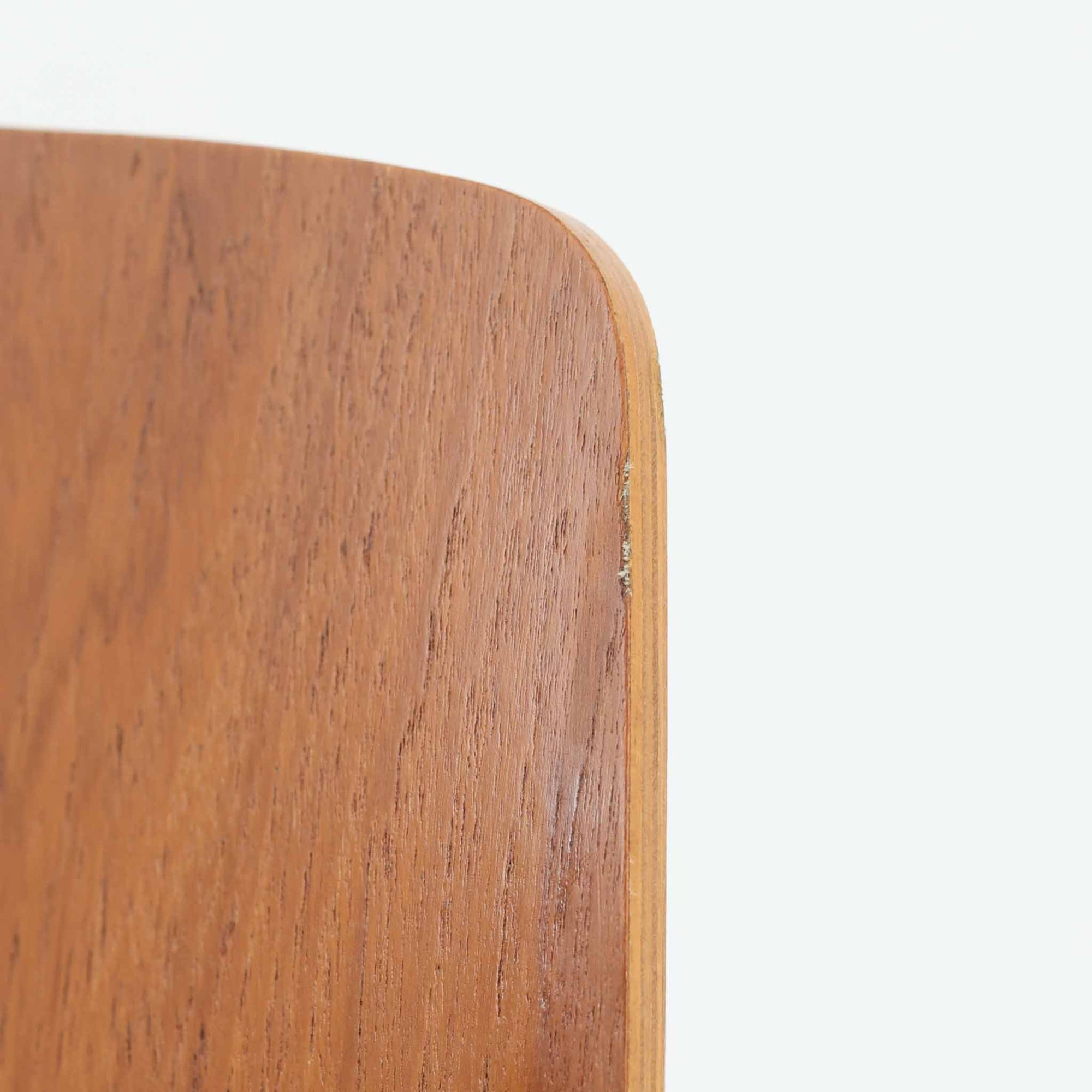 アルネ・ヤコブセンがデザインし、Fritz Hansenが製造した「T Chair」です。チーク材の成形合板による背座一体型のシェルは、背面上部を左右に広げた特徴的なシルエットと、身体に沿う緩やかな曲面が魅力。細身の金属脚との組み合わせが軽快で、ダイニングはもちろん、書斎や玄関のアクセントチェアにもおすすめです。美しい木目と時を重ねた風合い、合理的な構造に宿る北欧ビンテージらしい存在感を楽しめます。