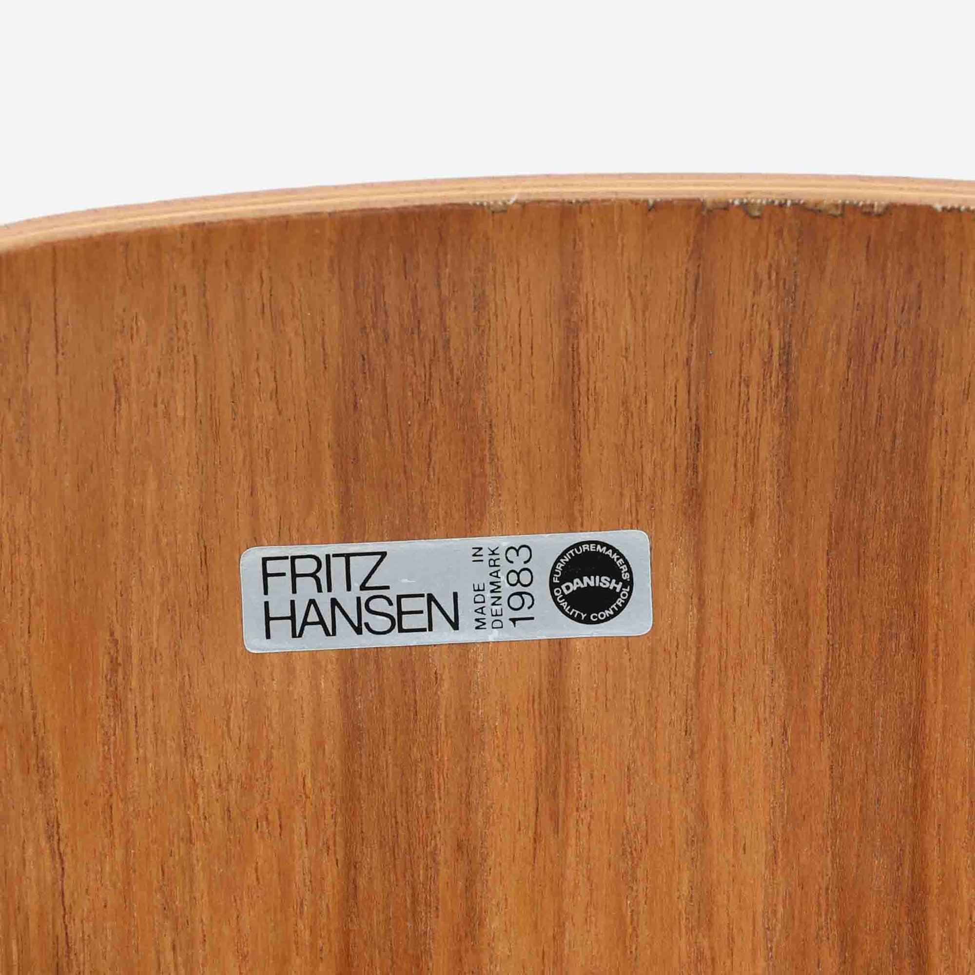 アルネ・ヤコブセンがデザインし、Fritz Hansenが製造した「T Chair」です。チーク材の成形合板による背座一体型のシェルは、背面上部を左右に広げた特徴的なシルエットと、身体に沿う緩やかな曲面が魅力。細身の金属脚との組み合わせが軽快で、ダイニングはもちろん、書斎や玄関のアクセントチェアにもおすすめです。美しい木目と時を重ねた風合い、合理的な構造に宿る北欧ビンテージらしい存在感を楽しめます。