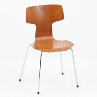 アルネ・ヤコブセンがデザインし、Fritz Hansenが製造した「T Chair」です。チーク材の成形合板による背座一体型のシェルは、背面上部を左右に広げた特徴的なシルエットと、身体に沿う緩やかな曲面が魅力。細身の金属脚との組み合わせが軽快で、ダイニングはもちろん、書斎や玄関のアクセントチェアにもおすすめです。美しい木目と時を重ねた風合い、合理的な構造に宿る北欧ビンテージらしい存在感を楽しめます。