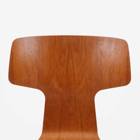 アルネ・ヤコブセンがデザインし、Fritz Hansenが製造した「T Chair」です。チーク材の成形合板による背座一体型のシェルは、背面上部を左右に広げた特徴的なシルエットと、身体に沿う緩やかな曲面が魅力。細身の金属脚との組み合わせが軽快で、ダイニングはもちろん、書斎や玄関のアクセントチェアにもおすすめです。美しい木目と時を重ねた風合い、合理的な構造に宿る北欧ビンテージらしい存在感を楽しめます。